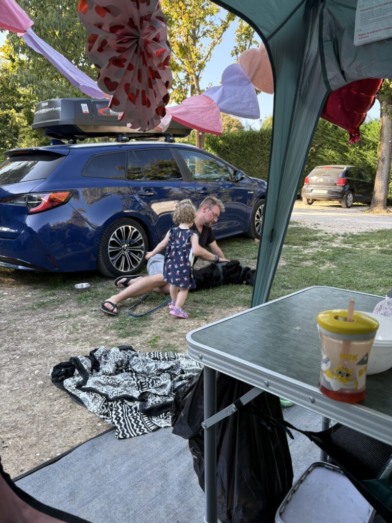 Familie beim Zelten mit Kleinkind und Hund
