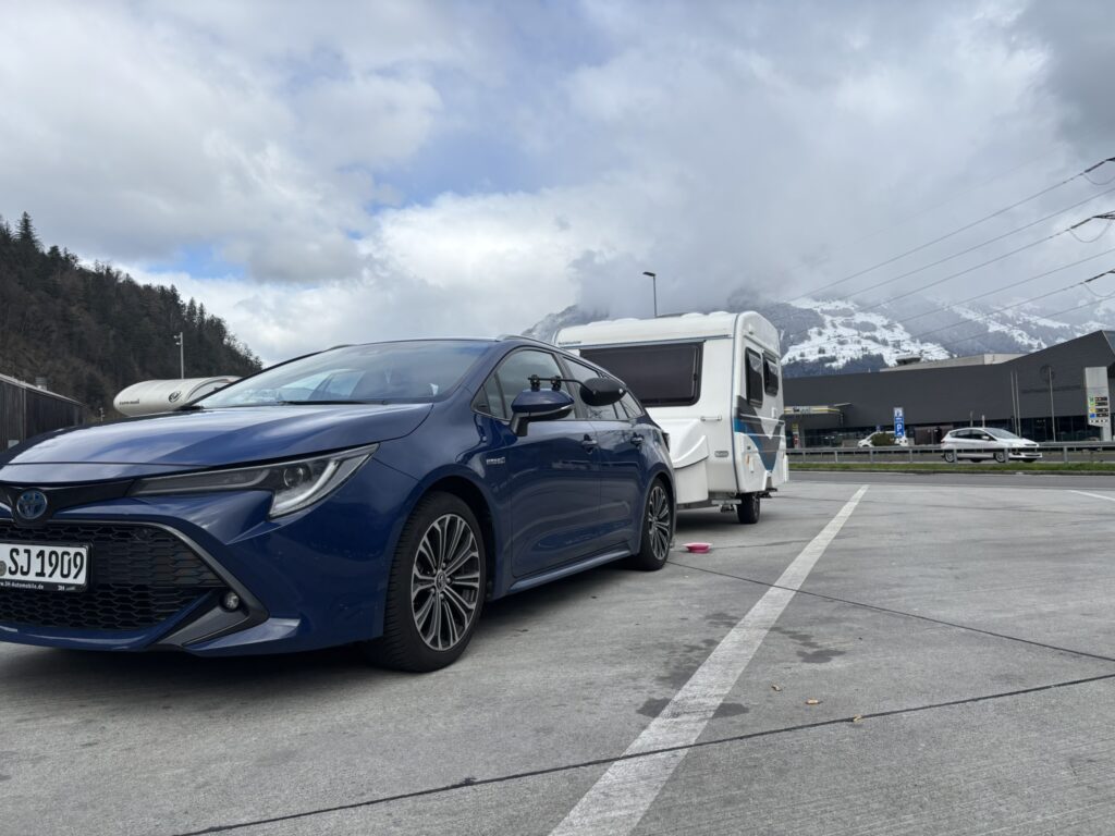 Toyota Corolla zieht Wohnwagen in den Alpen
